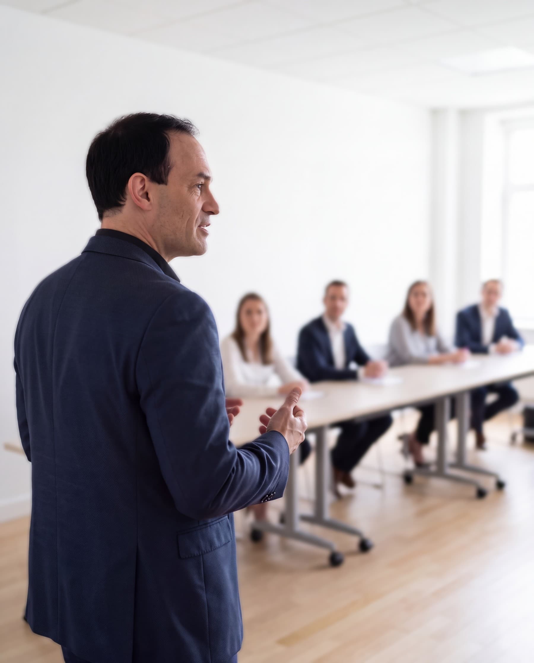 Michael Backes speaking to a small group seated at a meeting table in a bright room